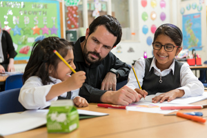 Male Primary School Teacher With Two Girl Pupils