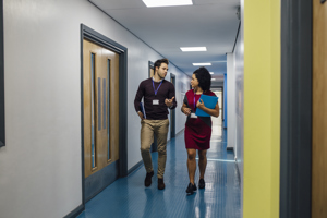 Two teachers walking along school corridor