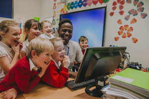 Pupils with teacher around a laptop