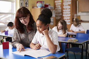 Female Teacher Young School Girl Reading A Book